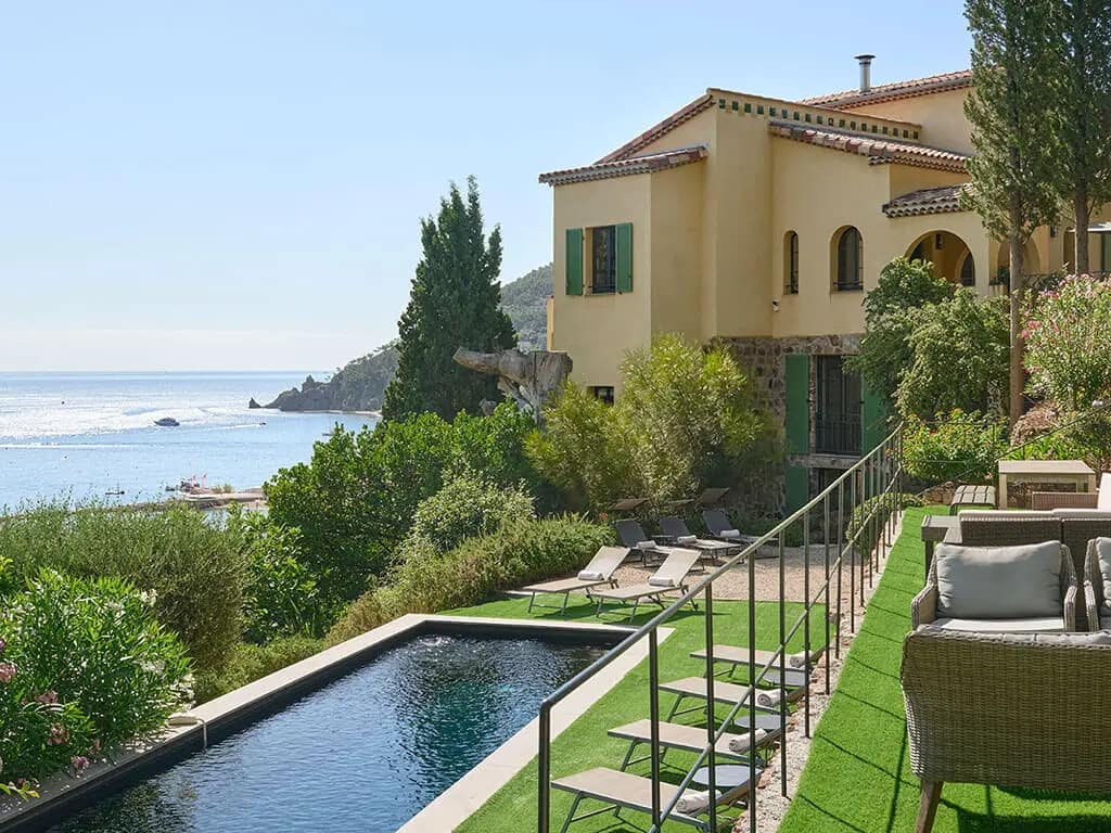 How To Find Off-Market Luxury Villas in the South of France 3 Image of a modern luxury villa with expansive glass walls, surrounded by greenery, illustrating the concept of how to find off-market luxury villas.